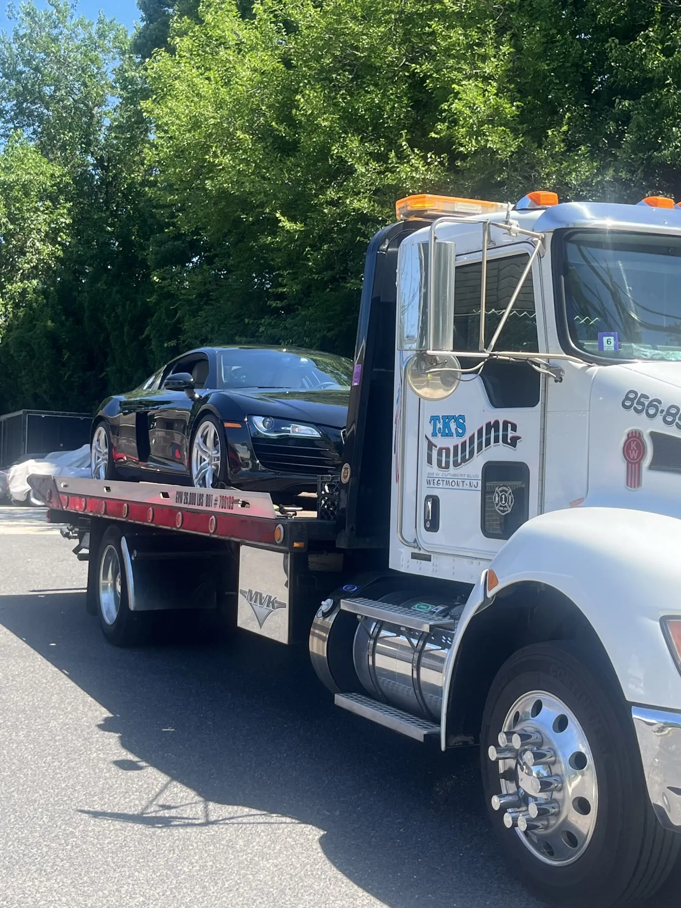 A black Audi sports car secured on the TK's Towing flatbed