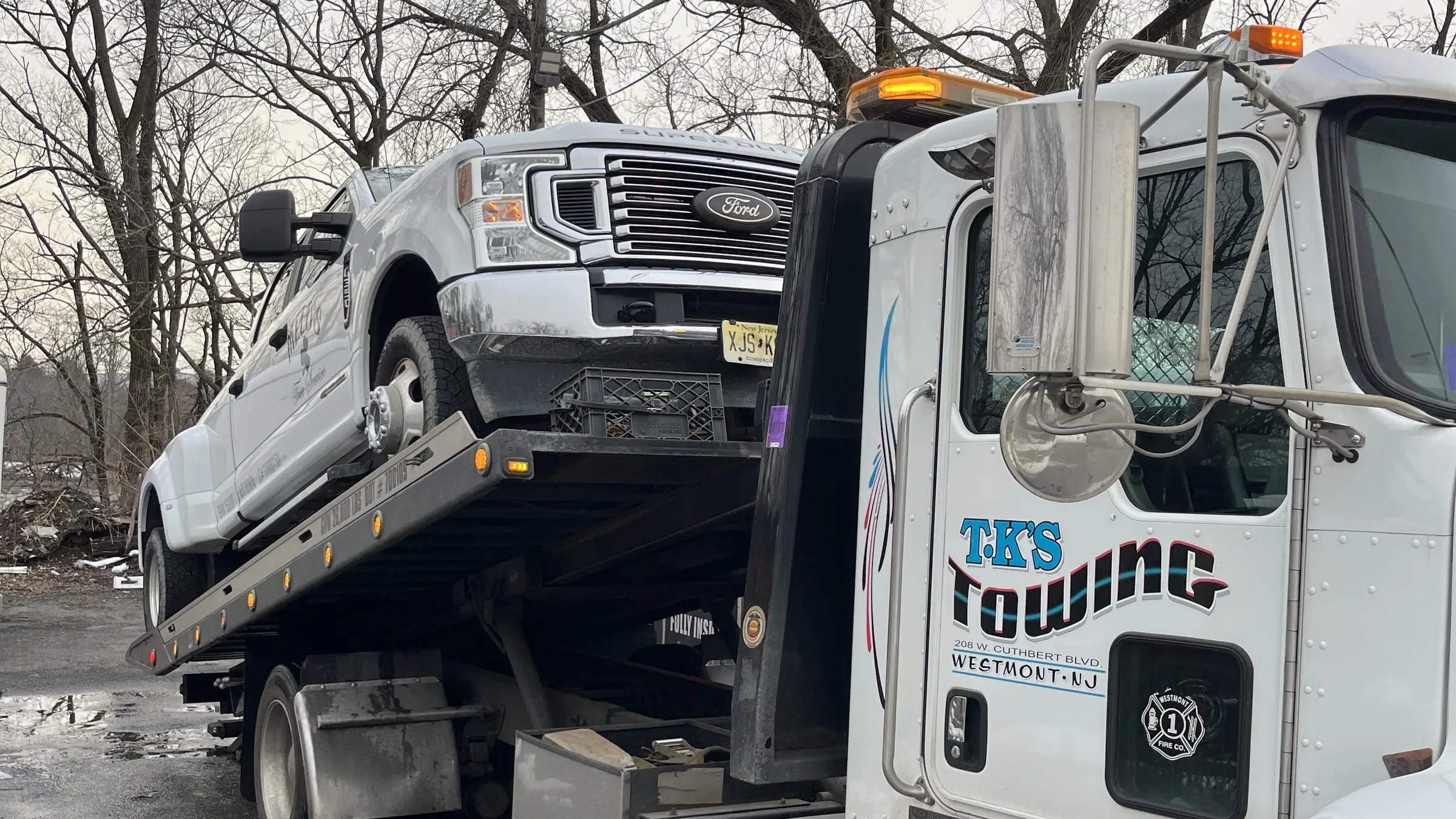 A white Ford F-250 Super Duty winched onto the TK's Towing flatbed