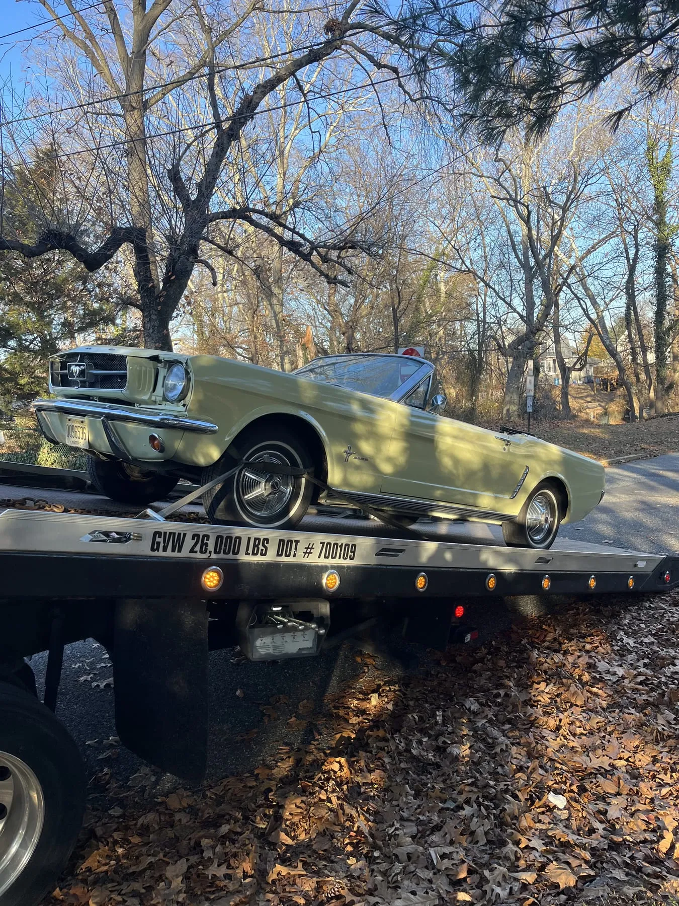 A classic Ford Mustang loaded on the flatbed