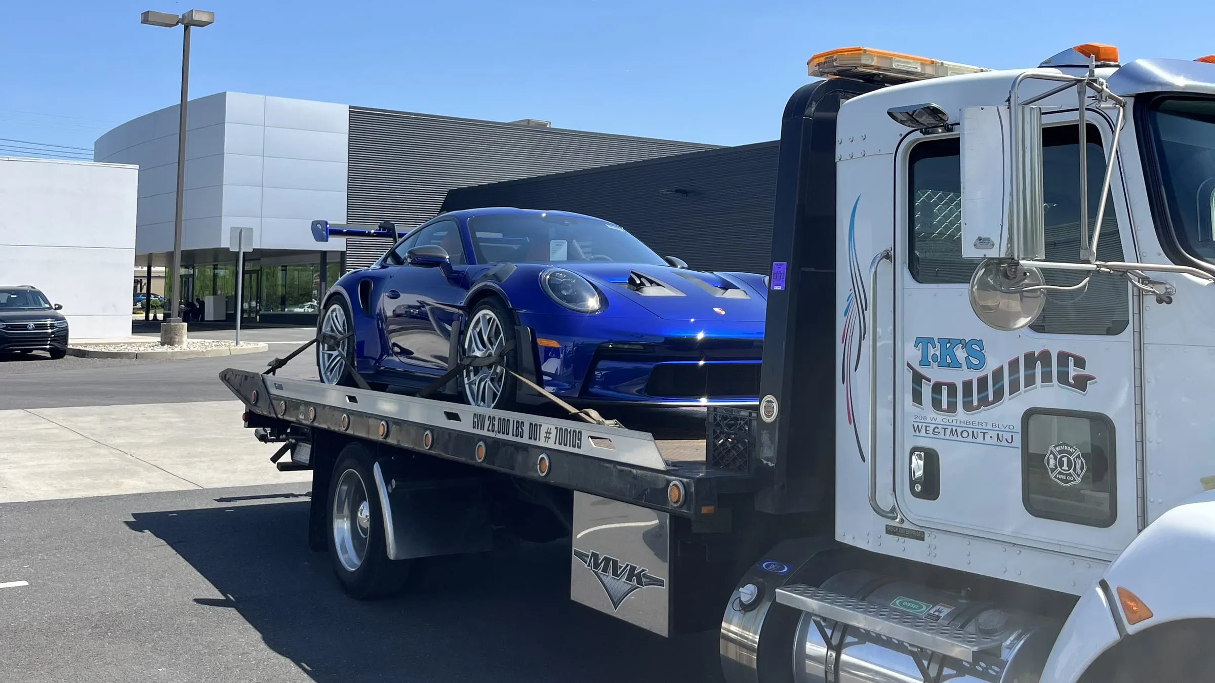 A blue Porsche 911 secured on the TK's Towing flatbed